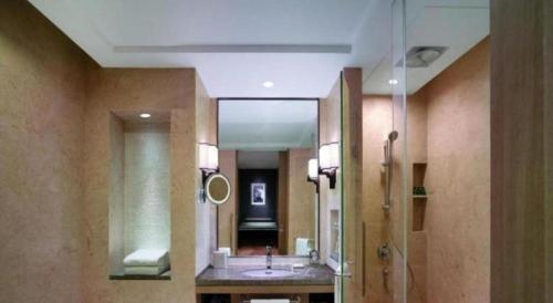a bathroom with a sink and a mirror at Linyi Blue Horizon Intenational Hotel in Linyi