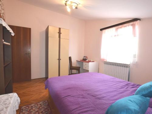 a bedroom with a purple bed and a desk at Comfortable holiday home only 500m to the sea with outdoor kitchen, wifi and airco in Banjole