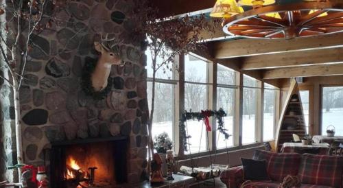 a living room with a stone wall with a fireplace at Birchwood Inn in Harbor Springs