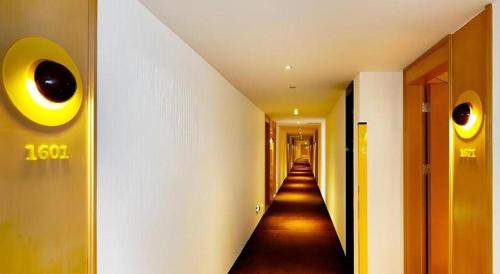 a hallway with a long hallway with eyes on the wall at 7 Days Premium Nanjing Gaochun Beiling Road Branch in Gaochun