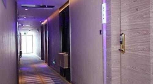 a hallway with purple walls and a hallway with a walkway at GreenTree Alliance Shenzhen Shekou Sea World Hotel in Shenzhen
