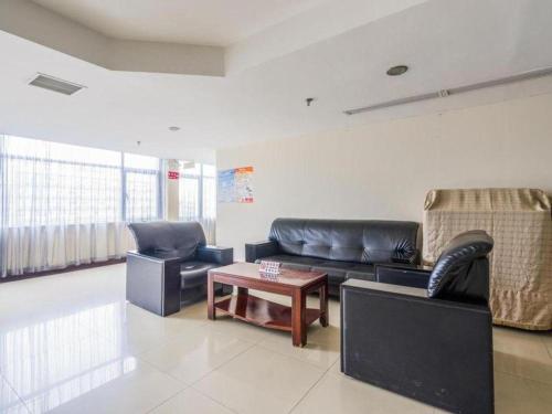 a living room with two leather couches and a coffee table at Movie Star Hotel in Guangzhou
