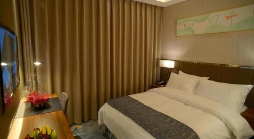 a hotel room with a bed and a table with a television at Beijing Friendship Hotel Jing Bin Building in Beijing