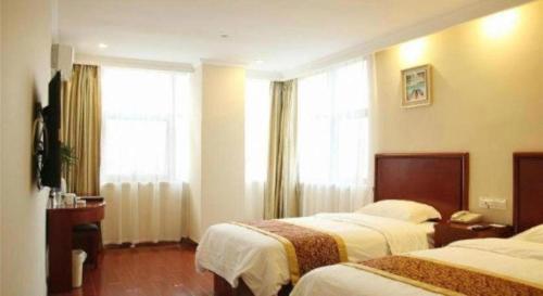 a hotel room with two beds and a window at GreenTree Inn Taizhou New District Hospital of Renmin Hospital Mingliu Express Hotel in Jiuligou