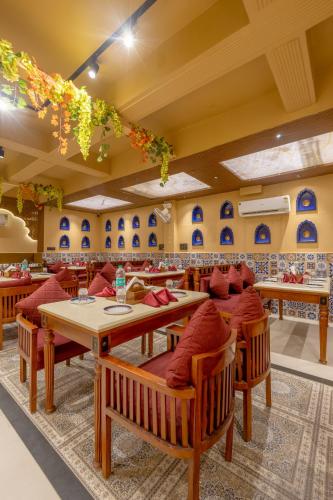 a restaurant with wooden tables and red chairs at Honeyveils Palace Hotel - Behind Indian Expo Mart in Greater Noida