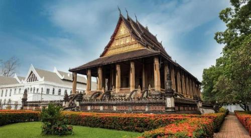 a pagoda in a garden in front of a building at Jian Guo Grand Hotel in Vientiane