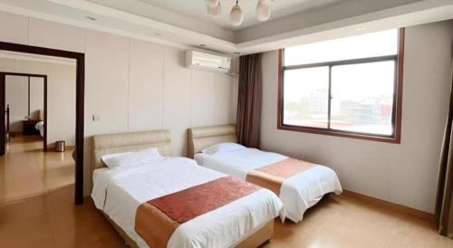 a hotel room with two beds and a window at Jian Guo Grand Hotel in Vientiane