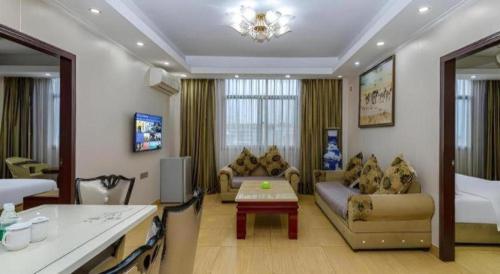 a living room with a couch and a table in a room at Jian Guo Grand Hotel in Vientiane