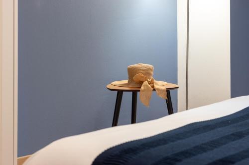 a hat sitting on a stool next to a bed at Residenze Blue Lake in Omegna