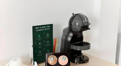 a black coffee maker sitting on top of a table at Merlin Hotel in Sungai Kolok
