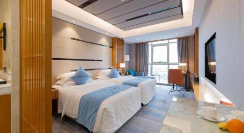 a hotel room with two beds and a television at Excemon Yuyao Hemudu Hotel in Ningbo