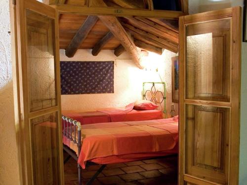 a bedroom with two beds in a room with wooden ceilings at Charming Stone Houses at Molino in Alájar