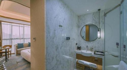 a bathroom with a shower and a sink and a mirror at Excemon Yuyao Hemudu Hotel in Ningbo