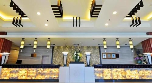 a lobby of a hotel with a counter and stairs at Excemon Yuyao Hemudu Hotel in Ningbo