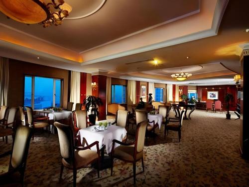 a restaurant with tables and chairs in a room at New Century Hotel Taizhou 