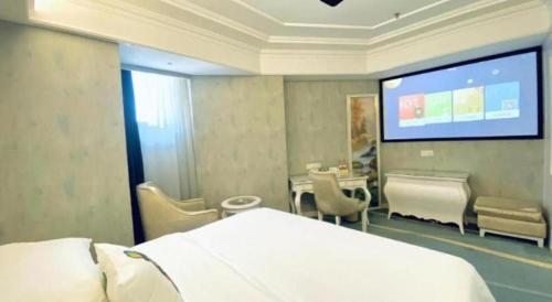 a hospital room with a bed and a projection screen at Vienna Hotel Guiyang Jiaxiulou Jichang Road in Guiyang
