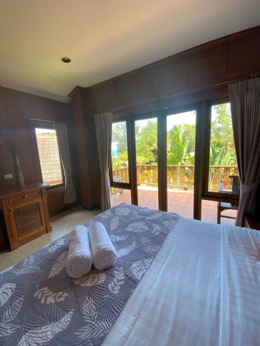 a bedroom with a bed with two pillows on it at Baan Laem Noi Villa's in Mae Nam