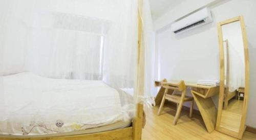 a bedroom with a bed and a desk with a mirror at Maximize Brand New Hostel Udonthani in Udon Thani