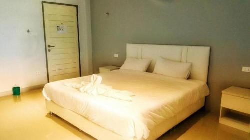 a bedroom with a large bed with white sheets at River Residence Saraburi Hotel in Sara Buri