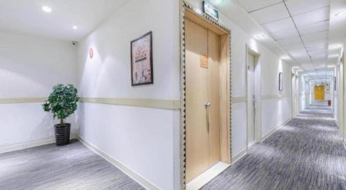 a hallway of an office with a door and a plant at Jinjiang Inn Wenzhou Shuangyu The Terminal in Wenzhou