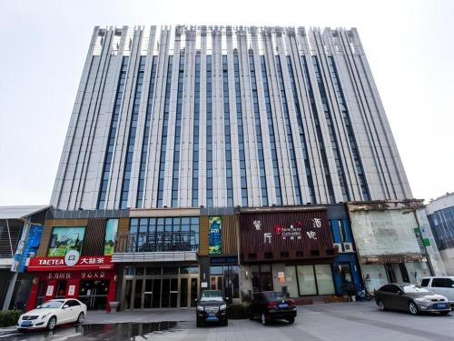 a large building with cars parked in front of it at Jinjiang Metropolo Hotel - Taizhou Wanda Plaza in Taizhou
