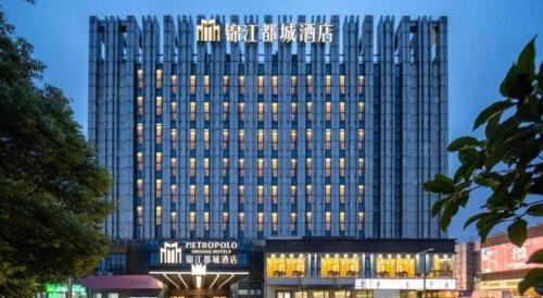 a tall building with a sign on top of it at Jinjiang Metropolo Hotel - Taizhou Wanda Plaza in Taizhou