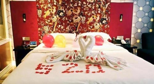 a bed with two swans made out of love hearts at Jinjiang Metropolo Hotel - Taizhou Wanda Plaza in Taizhou