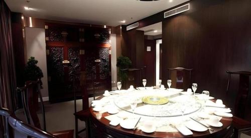 a round table with white plates and napkins on it at Tianjin Juchuan Lily Hotel in Binhai