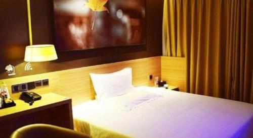 a bedroom with a bed and a desk with a phone at IU Hotel Chengdu High-Tech Zone Longhu Times Street in Chengdu