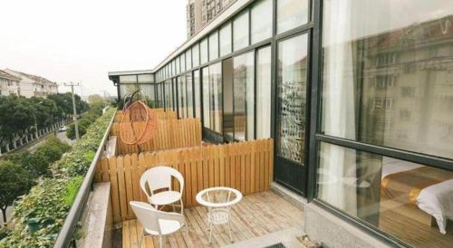 a balcony with two chairs and a bed on a building at Shell Shanghai Jiading Nanxiang Town Minzhu Street Hotel in Shanghai