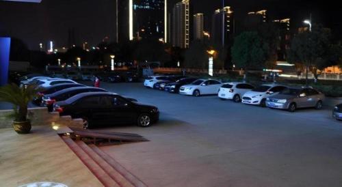 a row of cars parked in a parking lot at night at GreenTree Inn Yancheng Yandu District Hongxing Macalline Century Avenue in Yancheng