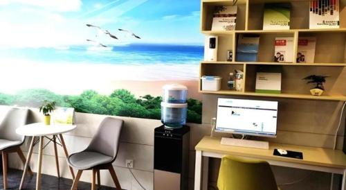 a office with a desk with a computer and a view of the ocean at Shell Hotel Shanghai Baoshan Meilanhu Luosheng Road in Shanghai