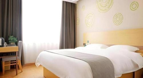 a bedroom with a large white bed and a desk at GreenTree Inn Express Gongqing City Nanchang University in Gongqingcheng