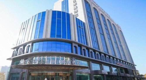 a large blue building with a lot of windows at Jinjiang Metropolo Hotel - Turpan Administration Center in Turfan