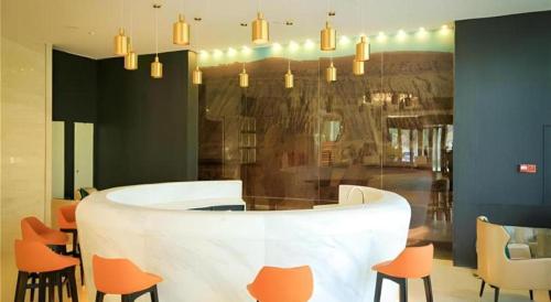 a lobby with a table and chairs in a room at Jinjiang Metropolo Hotel - Turpan Administration Center in Turfan