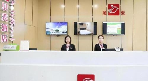 two women sitting at a counter in a store at Shell Taiyuan South Station Shanxi University Hotel in Taiyuan