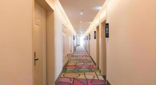 a hallway with a colorful tile floor in a building at Shell Taiyuan South Station Shanxi University Hotel in Taiyuan