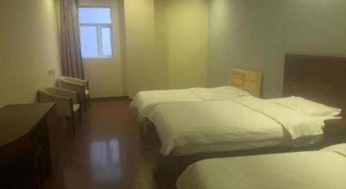 a hotel room with three beds and a window at GreenTree Inn Changzhou Wujin Bus Station in Changzhou