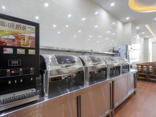 a row of stainless steel food machines in a restaurant at GreenTree Inn Jiaxin Puyuan Kaixuan Road in Jiaxing