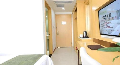 a room with a tv and a bed and a room at GreenTree Inn Jiaxin Puyuan Kaixuan Road in Jiaxing