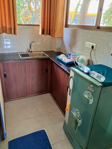 a kitchen with a small refrigerator and a sink at Jagabay Resort & Surfing School in Weligama