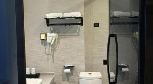 a bathroom with a toilet and a phone on the wall at GreenTree Inn Ganzhou Gan County Bus Station in Ganzhou