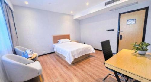 a bedroom with a bed and a desk and a table at GreenTree Inn Ganzhou Gan County Bus Station in Ganzhou