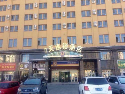 a large building with cars parked in front of it at 7 Days Inn Yining Xintiandi in Kipekyüzi