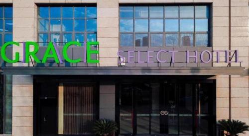 a large building with a green sign on it at GRACE Select Hotel (Kunshan Huaqiao International Convention Center) in Suzhou
