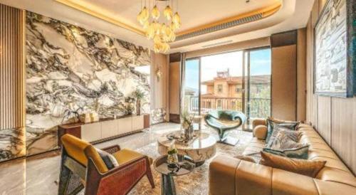 a living room with a couch and a large window at Emerald Bay Hotel in Yuxi