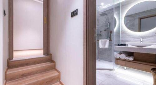 a bathroom with a sink and a shower and a mirror at Emerald Bay Hotel in Yuxi