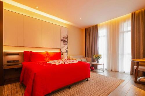 a bedroom with a red bed in a room at Wanda JIN Baise in Baise