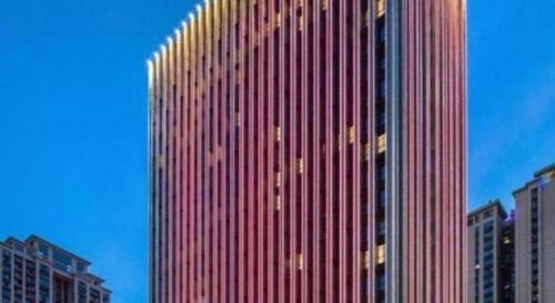 a tall red building in a city with buildings at Wanda JIN Baise in Baise