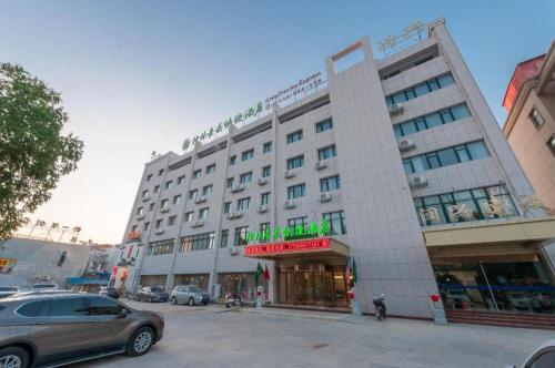 a large white building with a car parked in front of it at GreenTree Inn Wuhu Eshan Road University City in Wuhu